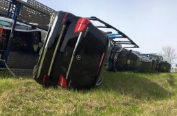 Truck full of Mercedes-Benz cars rolls over